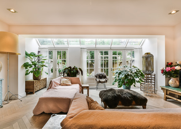 modern living room with natural light and plants featuring a cozy seating arrangement ideal for three people