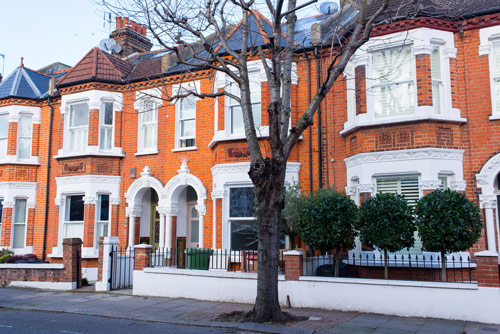 Victorian terraced houses with a tree in front, located in West London.
